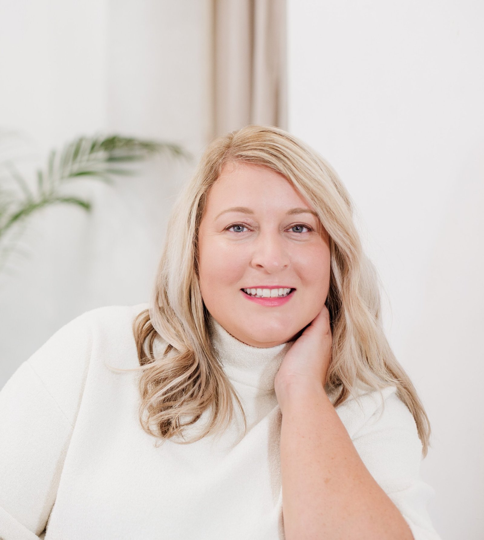 Coaching psychologist specialising in burnout recovery, smiling warmly in a calm, welcoming space